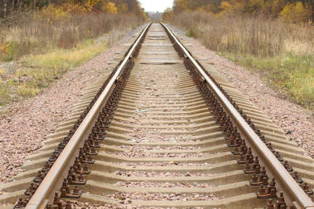 Close-up - Autumn sunset on the rail. Autumn background - the railway tracks recede over the...