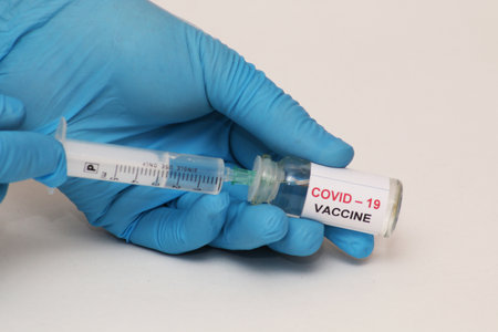 Covid-19 corona virus fight concept. The doctor is ready to vaccinate against coronavirus, holds a...