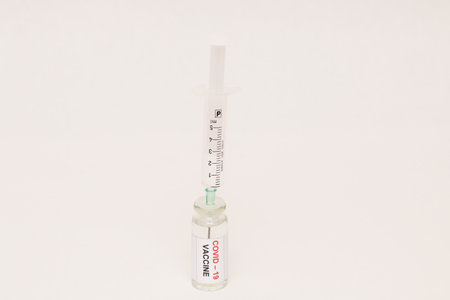 The concept of combating the coronavirus Covid-19. On a white background, a jar with a vaccine and a...