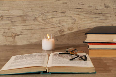 Preparing for exams at the university with a burning candle on a wooden table.の写真素材
