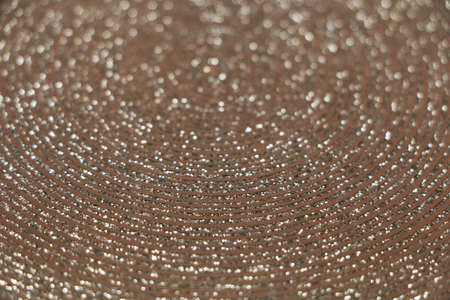 Abstract background of shiny rings of gray, black and beige colors with iridescent glitter. The...
