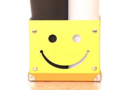 Yellow paper box with multi-colored background for photographing. Bright box for documents on the table in the office.の写真素材