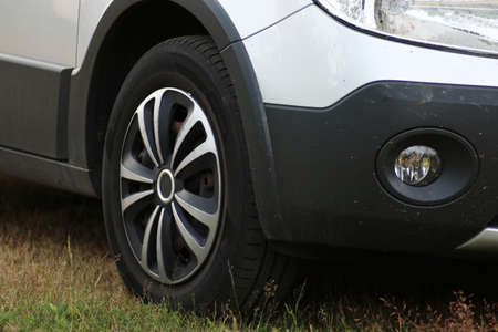 Front wheel of a passenger car close-up. Automotive wheel caps. Car tuning.の写真素材