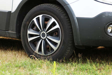 Front wheel of a passenger car close-up. Automotive wheel caps. Car tuning.の写真素材