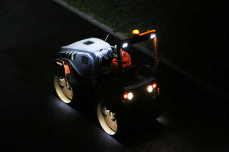 Road repair works at night. Modern machines for the repair and paving of new asphalt.の写真素材