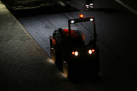 Road repair works at night. Modern machines for the repair and paving of new asphalt.の写真素材
