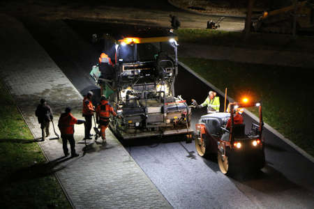 Road repair works at night. Modern machines for the repair and paving of new asphalt.の写真素材