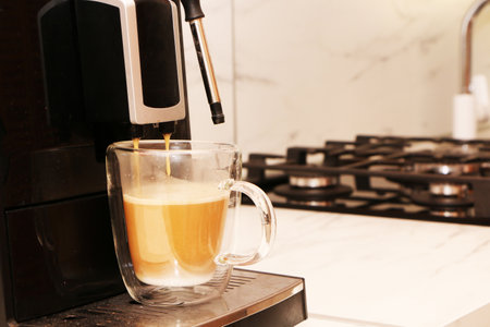 A man prepares aromatic delicious coffee in an automatic coffee machine. Coffee with milk is prepared in a coffee machine.の写真素材
