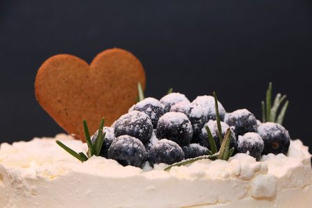 Festive cake decorated with blueberries. Christmas cake against the backdrop of New Year's decorations.の写真素材