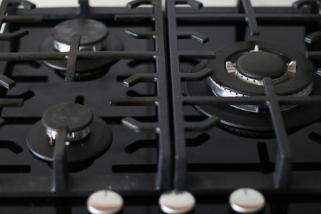 Black ceramic gas stove close-up. Blue flame on a working modern gas stove.の写真素材