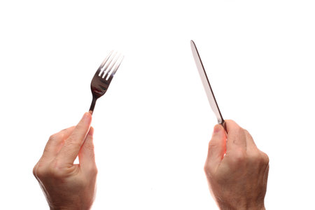 Knife and fork in hands on a white backgroundの写真素材