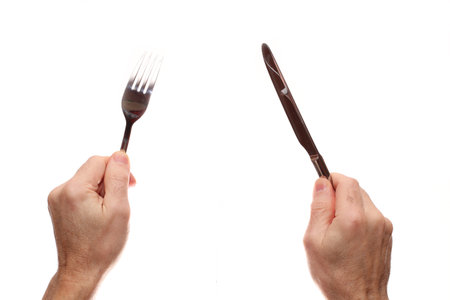 Fork and knife in hands on a white background. Isolateの写真素材