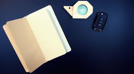 Close up empty book, snail compass and car key on shiny blackboard, traveler items for memo, direction and vehicle. vintage background with copy spaceの写真素材