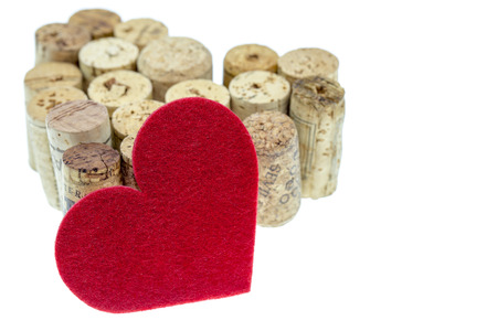 Red textile heart with wine corks form a heart shape on isolated white backgroundの写真素材