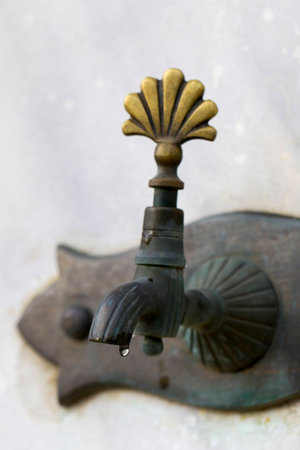 Drop of water dripping closeup from Turkish ottoman style antique water tap. Antique Ottoman faucetの写真素材