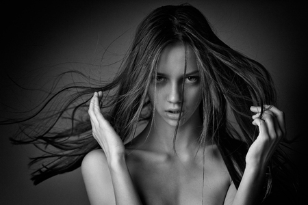 close-up portrait of a beautiful young girl with long hair flying in the wind.の写真素材
