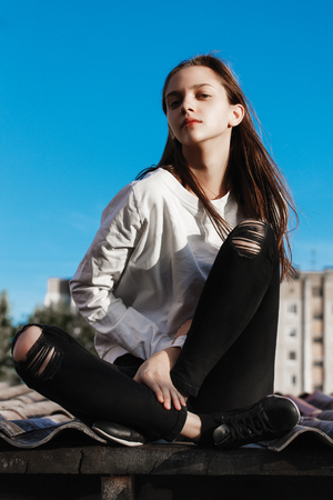 a beautiful young girl sitting sadlyの写真素材