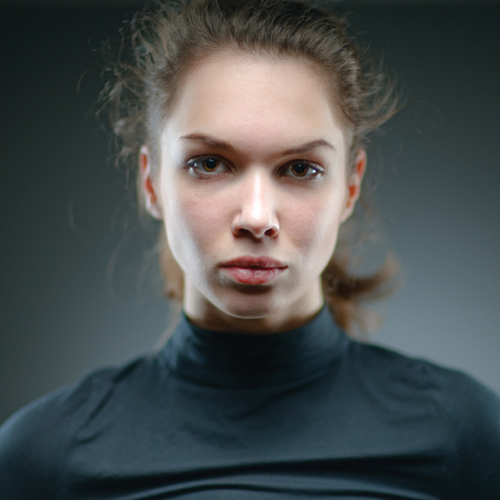 Portrait of a normal girl looking camera. / Beautiful woman portrait over grey background. Shallow depth-of-field.の写真素材