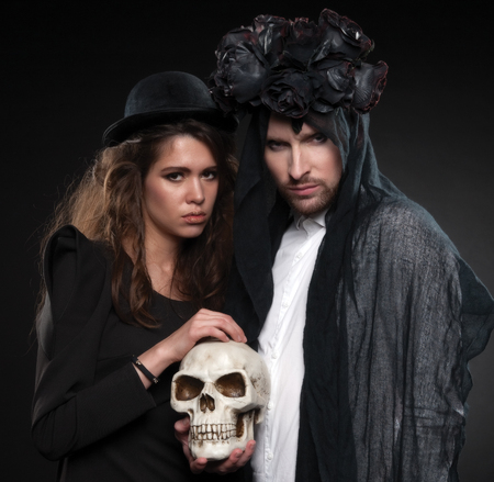 Classic vintage woman poses with black roses and her husband in makeup for All Souls Dayの写真素材