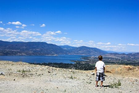 boy is watching horizon from the mountainの写真素材
