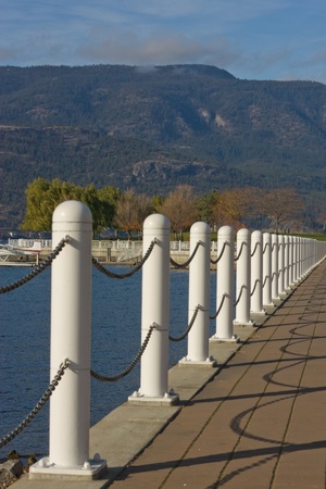 white chain handrails along lakeshore with mountain viewの写真素材