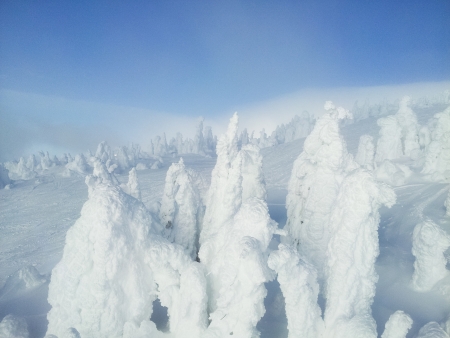 Beautiful sunny day on mountain top, smooth snowy hills and snow surface, clear and blue sky, cold windy day on glacier, winterの写真素材