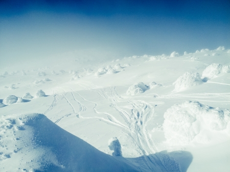 Beautiful sunny day on mountain top, smooth snowy hills and snow surface, clear and blue sky, cold...