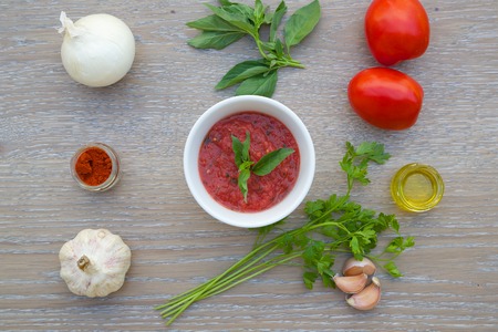 Ingredient for preparing Italian tomato sauce - salsa on the wooden surface. Salsa in the white ceramic dish.の写真素材