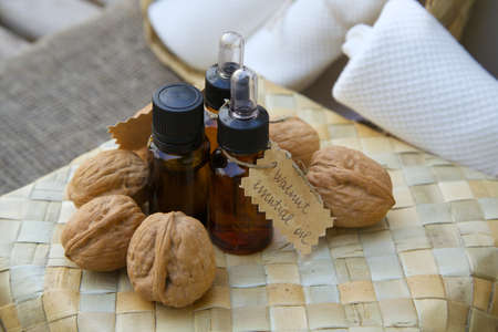 Bottle of walnut essential oil on the woven surface. Walnuts in the backgroundの写真素材