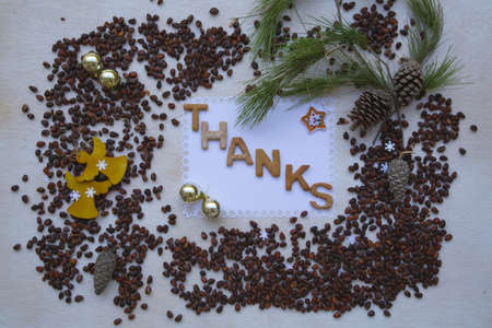 Winter holidays cedar nuts background on a wooden surface with inscription:"Thanks"の写真素材