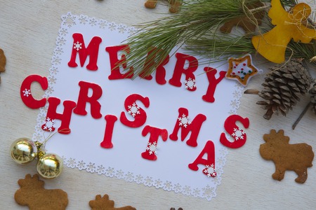 Christmas background on a white wooden surface with inscription: Merry Christmas