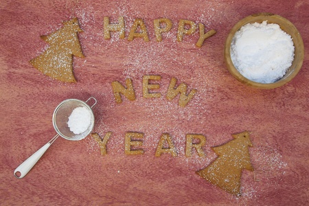 New Year's Day background with biscuit inscription: Happy New Year.Tea strainer and an olive wood...