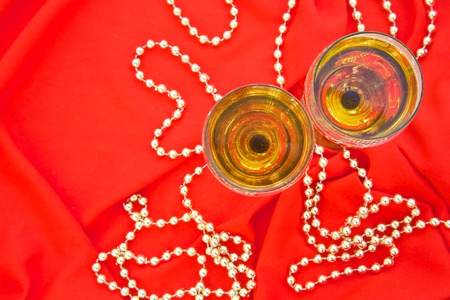 Two glasses of white wine on a bright red fabric. Top viewの写真素材