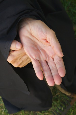 An old woman dressed in black is begging for breadの写真素材