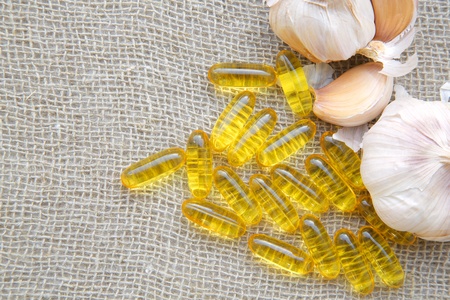 Garlic oil in the capsules on a sackclothの写真素材