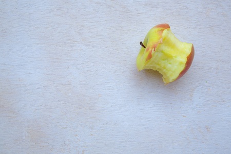 An eaten apple on a white wooden surfaceの写真素材