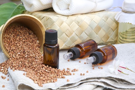 A dropper bottle of buckwheat oil on a sackclothの写真素材