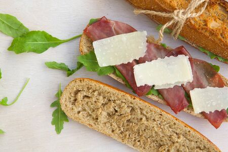 Sandwiches with whole grain bread, rucola,parmesan cheese and bresaola. Free space for a text.の写真素材