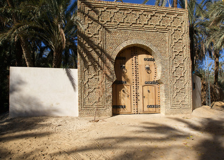 Huge olive wood door in Tunisian oasisの写真素材