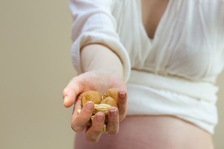 Nuts in the hand of pregnant womanの写真素材