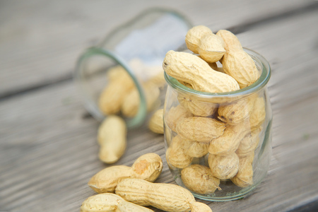 Peanuts in the glass on an old wooden surface.Close upの写真素材