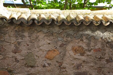 A concrete wall covered by old roof tile. Backgroundの写真素材