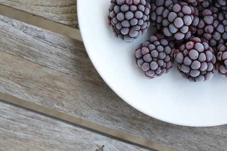 Flozen blackberries on a white plate. Background