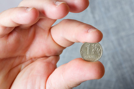 A coin of one rouble in the hand of a business man. Closeup.の写真素材