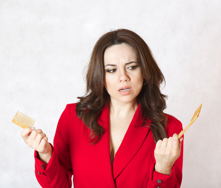 A young woman and a broken wooden made hair brushの写真素材