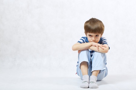 A boy of six years old show that he is angry with others on a white background  . Free space for a...