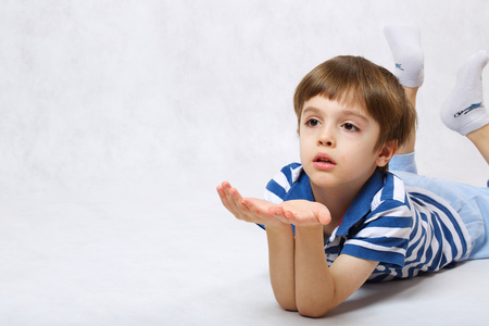 A boy of six years old imagines that his keeps something in his palms. Free space for a text.の写真素材