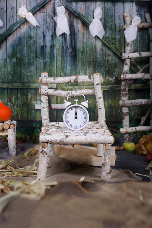 Alarm clock on a birch tree bed in haunted house in Halloween night. Closeup
