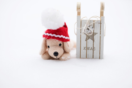 Winter holidays background:  small plush dog in Santa hat on a snow. Closeupの写真素材