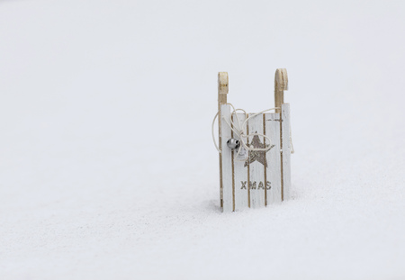 Winter holidays background:  wooden made sleigh in the snow. Closeup